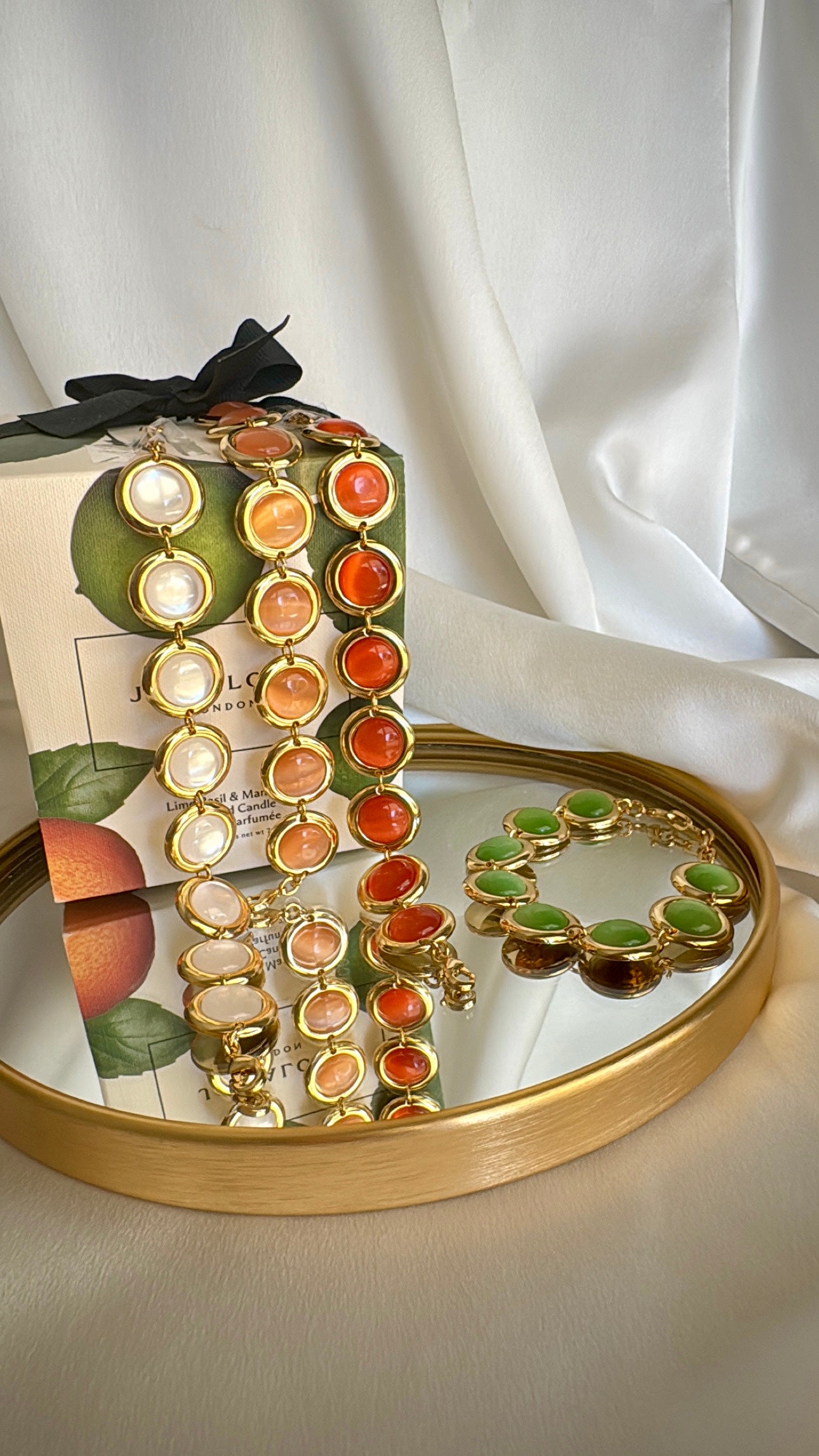 Gold plated stainless steel bracelet with colorful enamel beads in coral, pink, green, and white