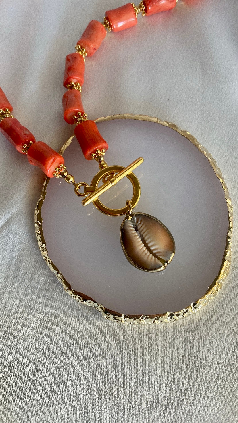 Bold summer necklace with coral beads and seashell pendant styled with beachwear