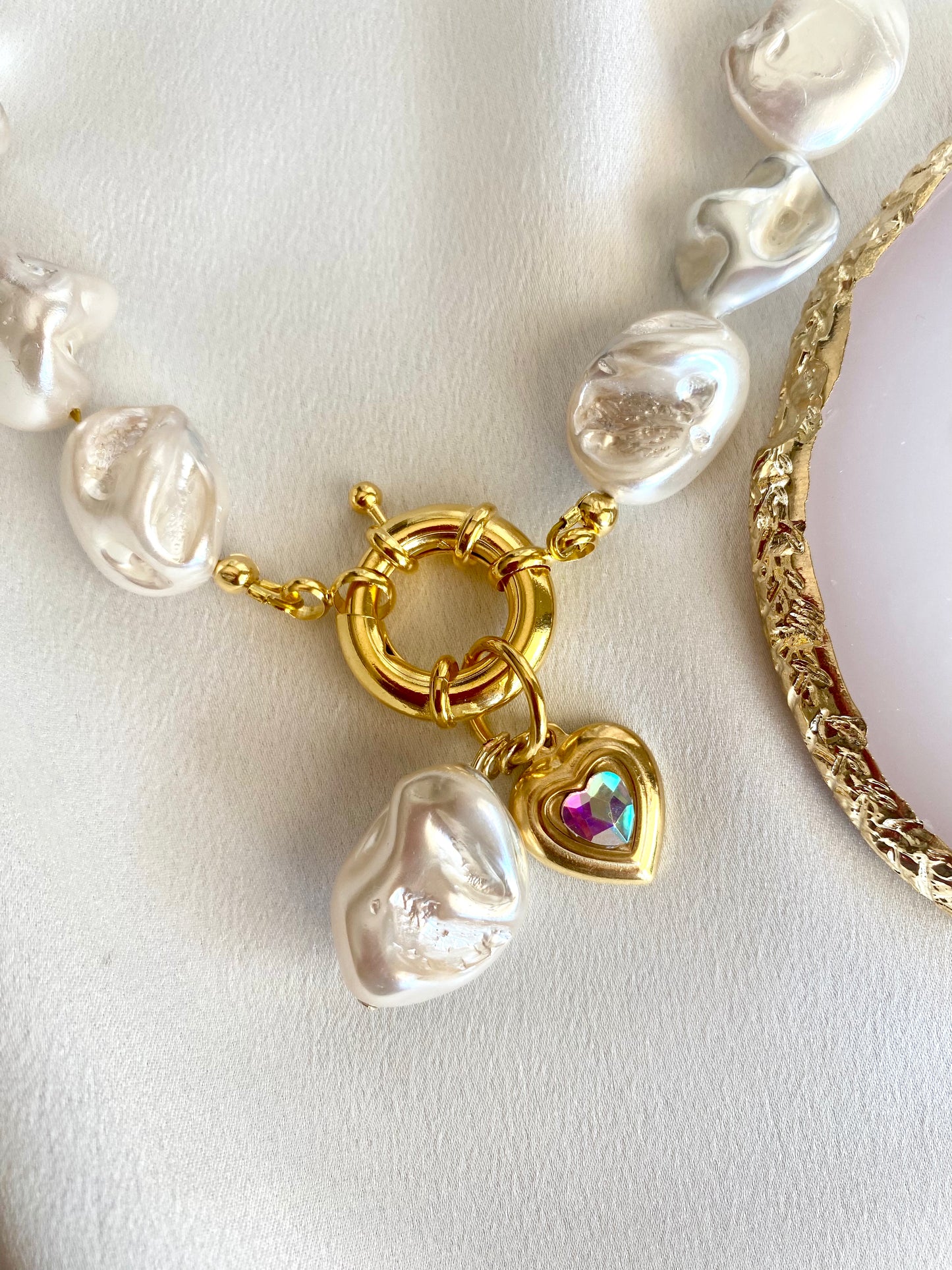 Detail of 24K gold-plated clasp with Mother of Pearl bead and crystal heart charm on JE T’AIME necklace