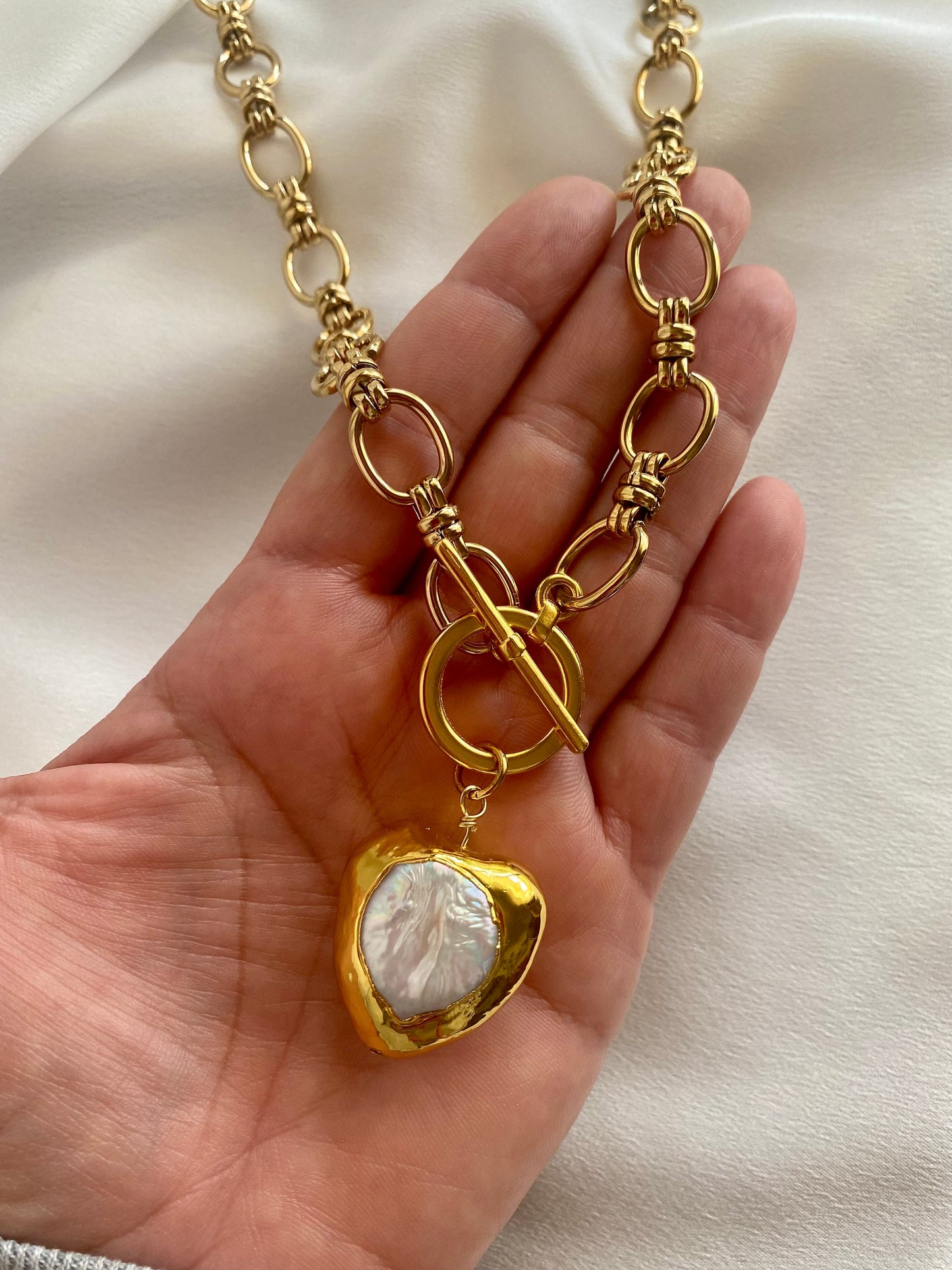 Close-up of MONICA necklace showing heart charm and 18k gold plated chain