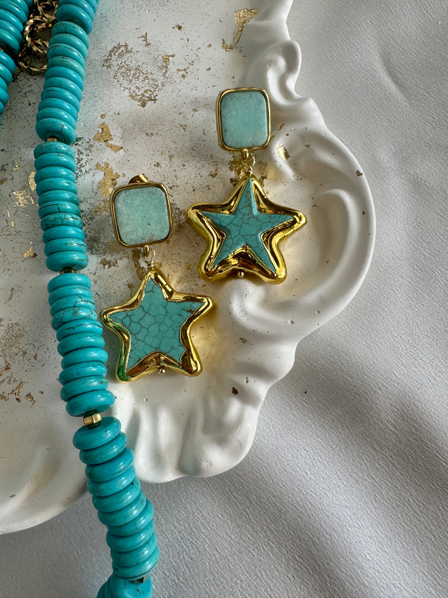 Handmade turquoise starfish earrings with gold-plated stainless steel details by LOTUS by M in white marble surface