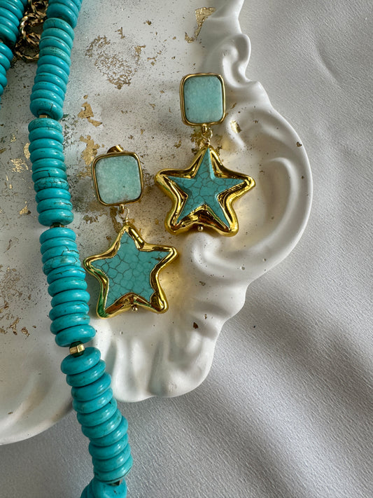 Handmade turquoise starfish earrings with gold-plated stainless steel details by LOTUS by M in white marble surface
