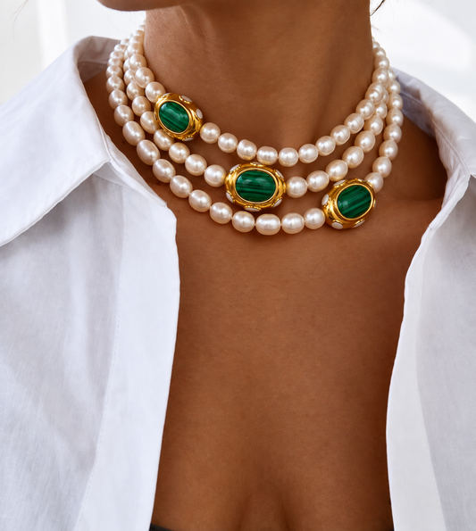 AIGLI pearl and green malachite necklace worn on neckline 3 times, styled with a white collared shirt.