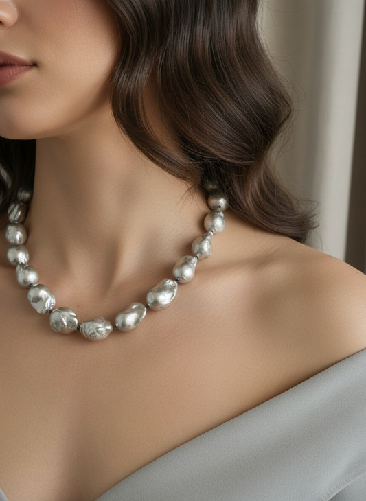 Pearl necklace worn by a model with a neutral background