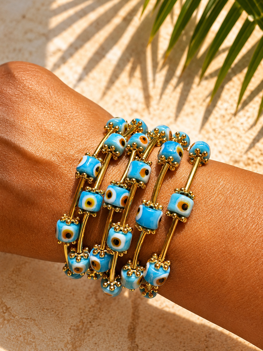 Turquoise beaded bracelet with gold accents on a wrist against a natural background