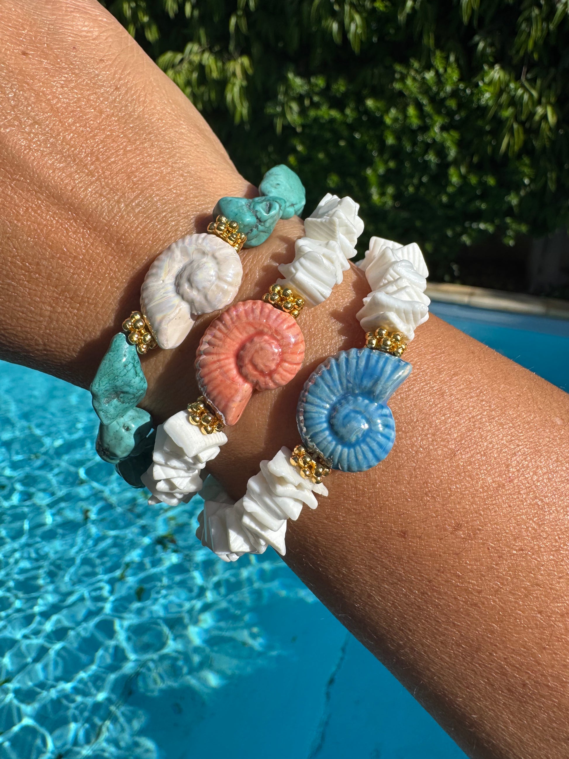 Woman wearing MYKONOS shell bracelet with summer outfit by the sea