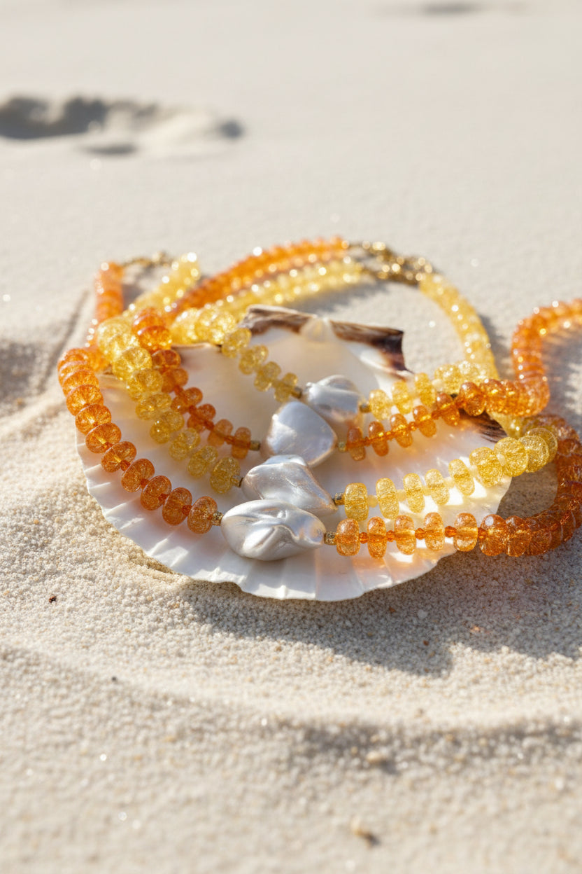 Beaded summer necklaces on a shell with a neutral background