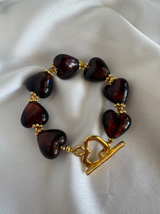 Bracelet with MURANO heart-shaped brown beads and a gold-plated stainless steel clasp on a white fabric background