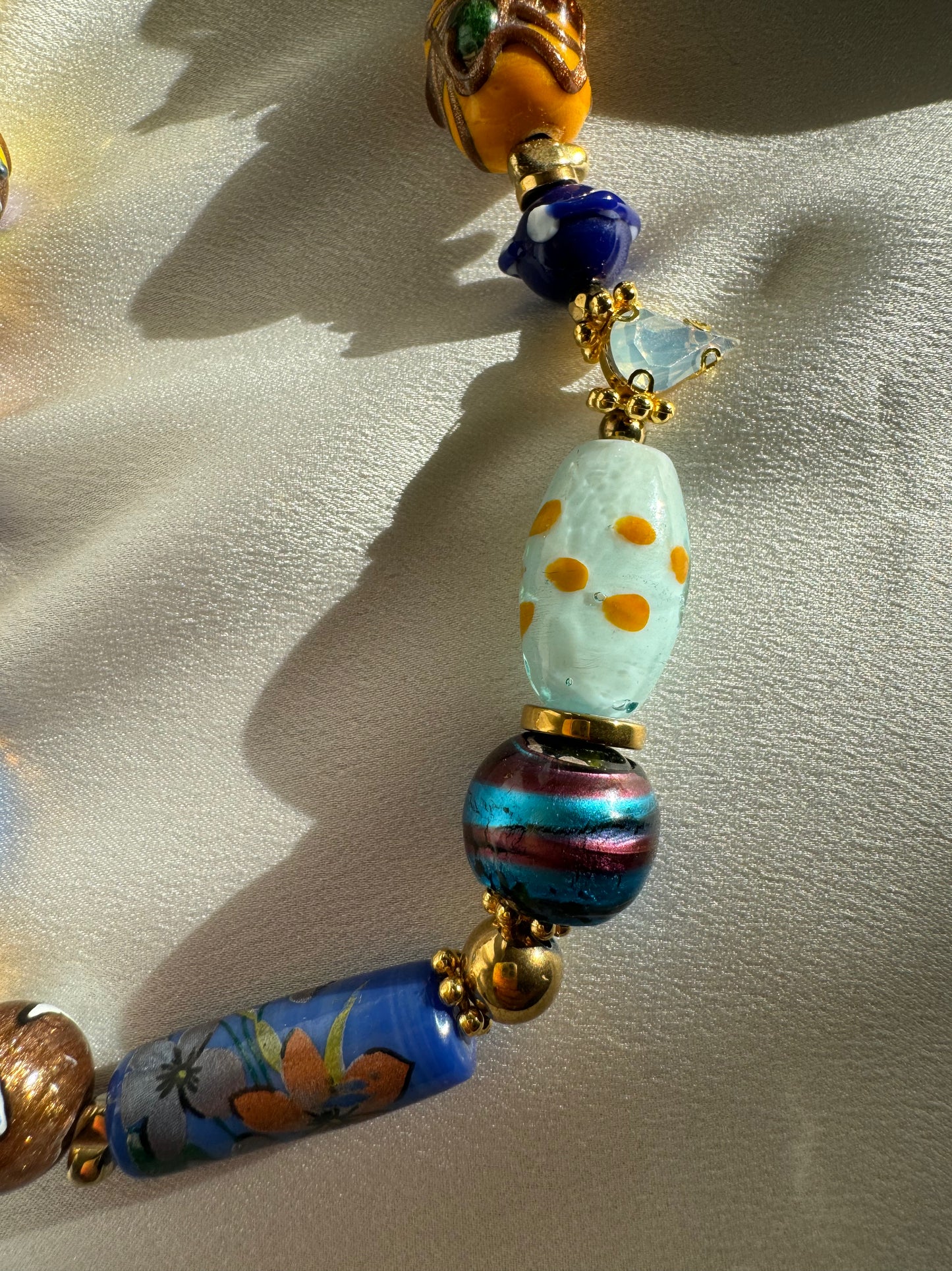 Close-up detail of colorful Murano beads and gold hematite accents on SAMIRA necklace