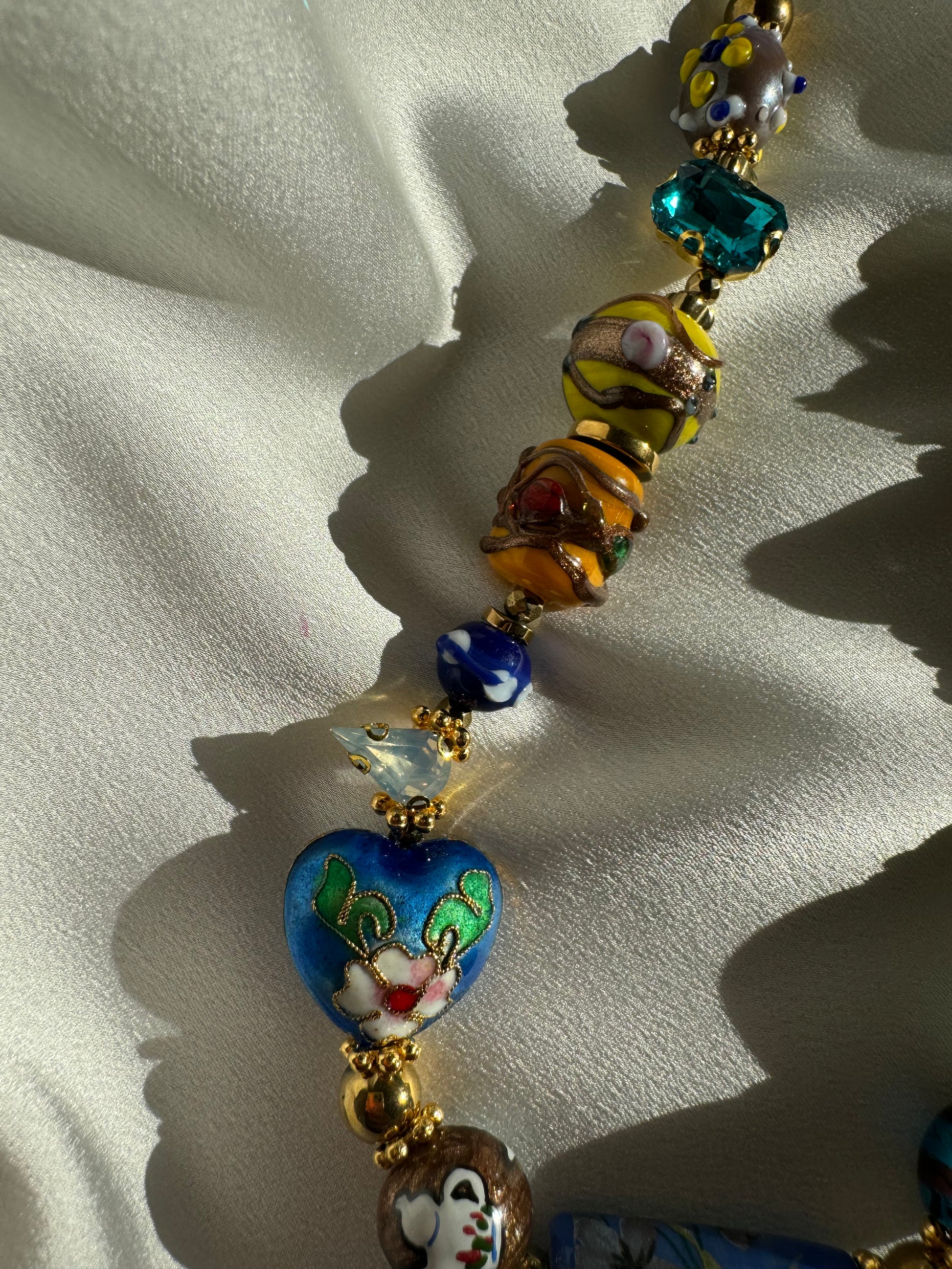 Close-up detail of colorful Murano beads and gold hematite accents on SAMIRA necklace