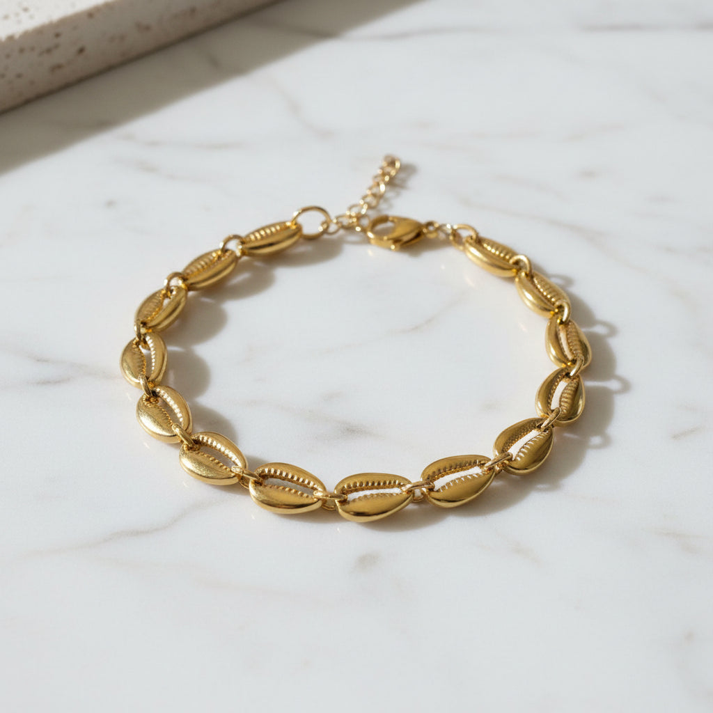 Gold shell bracelet on a textured stone surface