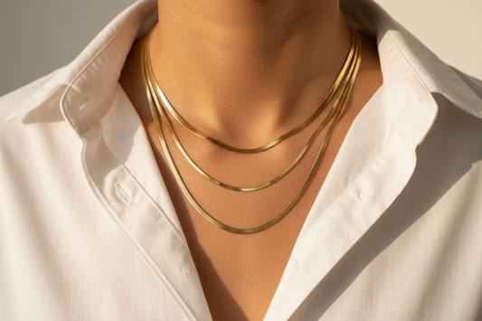Gold necklaces on a person wearing a white shirt